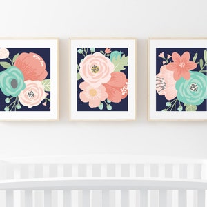 May include: Three framed prints with floral designs on a navy blue background. The flowers are in shades of pink, coral, and teal.