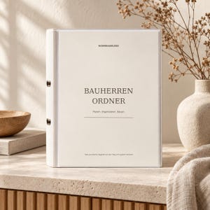 Könnte beinhalten: Ein weißer Ringordner mit einer transparenten Fronttasche, die ein Deckblatt enthält. Der Text auf dem Deckblatt lautet WOHNRAUMLIEBE, BAUHERREN ORDNER, Planen, Organisieren, Bauen und Dein persönlicher Begleiter auf dem Weg zum eigenen Zuhause.