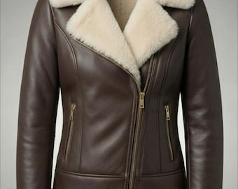 Könnte beinhalten: Braune Lederjacke mit cremefarbenem Shearling-Futter und -Besatz. Die Jacke hat einen diagonalen Reißverschluss, zwei Reißverschlusstaschen und Shearling-Manschetten. Der Kragen ist ebenfalls mit cremefarbenem Shearling gefüttert.