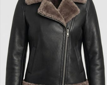 May include: Black leather jacket with a shearling collar and trim. The jacket features an asymmetrical zipper closure and long sleeves. The shearling is a light brown color, contrasting with the black leather.