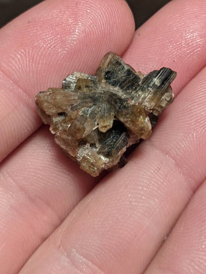 May include: A cluster of brown and green crystals with a rough, natural texture.