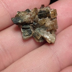 May include: A cluster of brown and green crystals with a rough, natural texture.