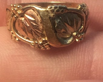 May include: A gold ring with a leaf design. The ring is made of three different shades of gold.