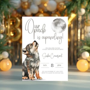 May include: A rectangular baby shower invitation card featuring a watercolor illustration of a wolf pup howling at a moon. The text reads: Our pack is expanding! Please join us for a baby shower honouring Sasha Crawford, Nov 8, 2pm, 123 Anywhere St.