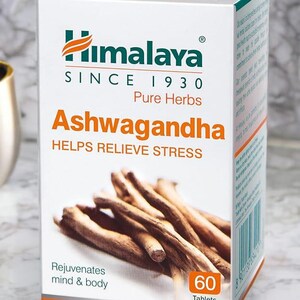 May include: A white box of Himalaya Ashwagandha tablets. The box features the Himalaya logo and the text "SINCE 1930 Pure Herbs." The box also states "HELPS RELIEVE STRESS" and "Rejuvenates mind & body." The box contains 60 tablets.