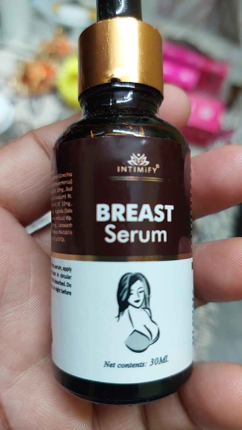 Puede incluir: Una botella marr&oacute;n de "BREAST Serum" con tapa dorada, con la silueta de una mujer. La etiqueta incluye la marca "INTIMIFY" y el texto "Net contents: 30ML".
