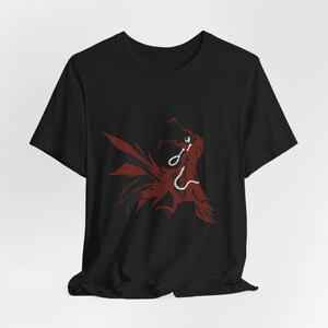 May include: Black t-shirt with a red graphic depicting a character with a flowing cape and a chain. The design is a stylized illustration, with the character's silhouette and cape in a bold red colour.