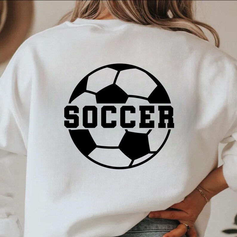 Pu&ograve; includere: Felpa bianca con un disegno di pallone da calcio nero e la parola "SOCCER" in lettere nere e in grassetto. Il disegno &egrave; centrato sul retro della felpa.