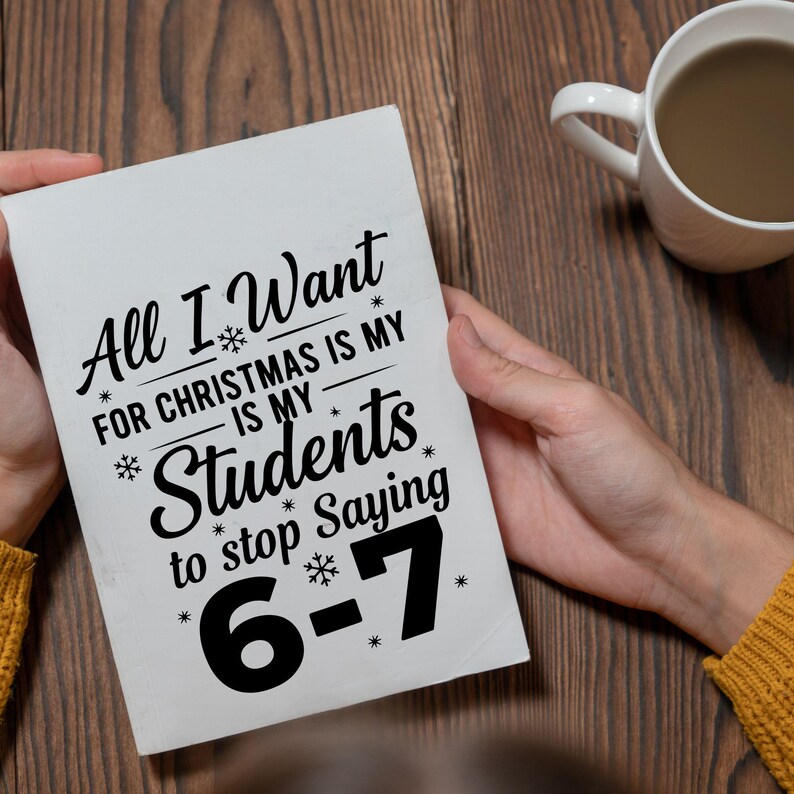 May include: A white rectangular sign held by a person, with the text "All I Want For Christmas Is My Students to stop Saying 6-7" in black script. The sign is decorated with snowflakes.