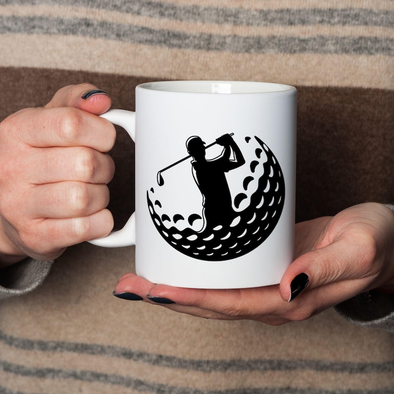 May include: A white ceramic mug with a black handle and the text "But First, Coffee" in a bold, black font. The mug is set against a blurred background, highlighting its clean design.