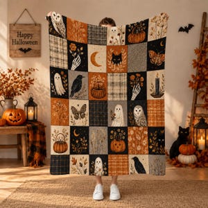 Könnte beinhalten: Eine rechteckige Wohndecke mit Patchwork-Design und Halloween-Motiven, darunter Geister, Eulen, schwarze Katzen, Kürbisse, Motten, Raben, Skelette, Mondsicheln und florale Muster in den Farben Orange, Schwarz und Grau.