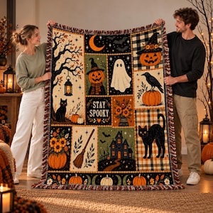 May include: A woven throw blanket featuring a patchwork design with Halloween motifs including pumpkins, a ghost, black cats, a haunted house, a broomstick, sunflowers, and the text "STAY SPOOKY" with a fringed edge on all sides.