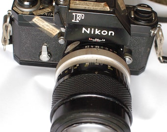 Black Nikon F Camera No. 6841486 with FTN Finder and Nikon 135mm f2.8 Nikkor Lens No. 178082 and off brand strap.