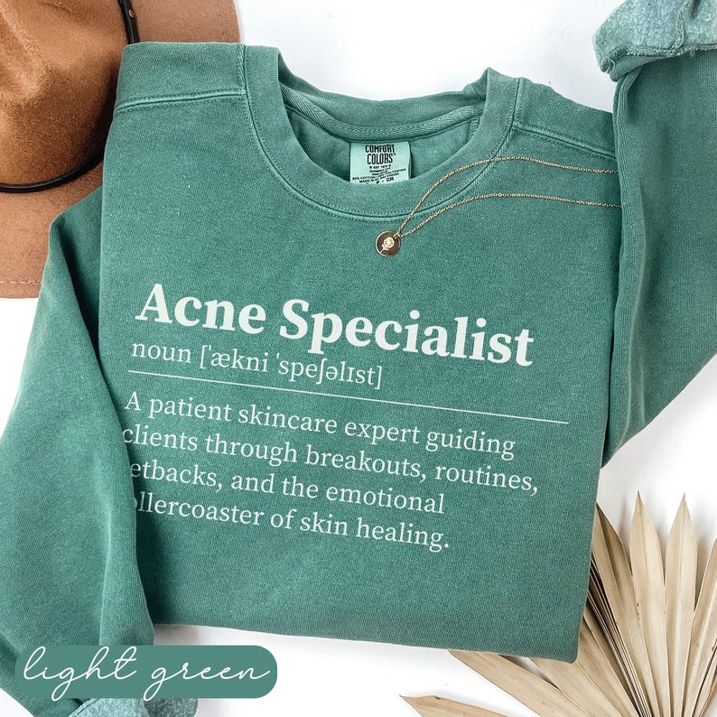 Sage green "Acne Specialist" sweatshirt with definition and light green text.