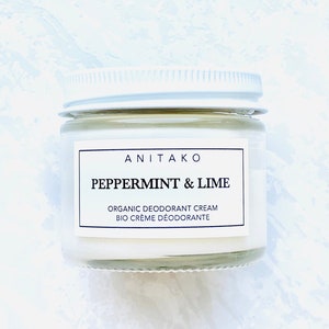 May include: A white jar with a white lid containing a natural deodorant cream. The label reads "ANITAKO PEPPERMINT & LIME ORGANIC DEODORANT CREAM BIO CREME DEODORANTE".