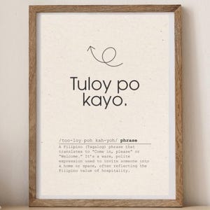以下が含まれることがあります： 「Tuloy po kayo」というフィリピンのフレーズが太字で書かれた額入りのプリント。その下には、英語で「ようこそ」という意味を説明する定義が書かれています。
