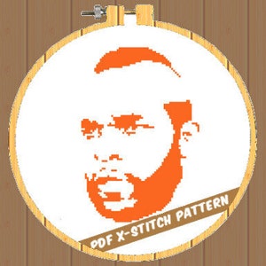 May include: A cross-stitch pattern featuring an orange pixelated portrait of a man with a beard, set against a white background within a wooden embroidery hoop. The text "PDF X-STITCH PATTERN" is visible on the bottom.