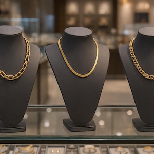 Könnte beinhalten: Ein Set aus drei Keramikbechern mit gesprenkelter, matter Oberfläche. Die Becher sind in Creme-, Hellgrau- und Dunkelgrautönen gehalten. Jeder Becher hat ein schlichtes, minimalistisches Design und einen abgerundeten Henkel.