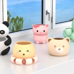 May include: A collection of whimsical animal-shaped planters. Includes a panda, cat, octopus, bear, and a smiling creature with tentacle-like legs. The planters are in various colors, including black, white, pink, yellow, and green. They are sitting on a white windowsill.