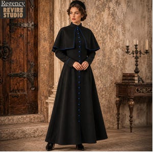 May include: A long black dress with a matching cape, featuring blue trim and buttons. The dress has a high collar and long sleeves. The image includes the text "Regency Revire Studio" in the upper left corner. The dress is a historical costume.