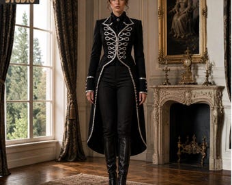 May include: A black military-style coat with silver trim and decorative buttons, paired with black pants and boots. The coat has a long, flowing back and is worn by a person standing in a room with a fireplace and a large window.