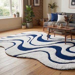 Könnte beinhalten: Ein weiß-blaues Wohnzimmer-Design-Teppich mit wellenförmigem Muster. Der Teppich liegt auf einem Holzboden in einem Wohnzimmer. Das Design zeigt geschwungene marineblaue Linien auf weißem Hintergrund.
