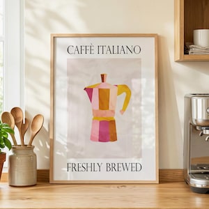 May include: A framed art print with a colourful illustration of a coffee maker. The print reads "CAFFÈ ITALIANO" at the top and "FRESHLY BREWED" at the bottom. The coffee maker is in shades of pink, yellow, and brown.