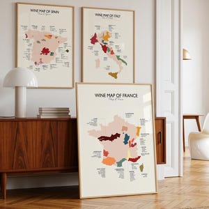 May include: Three framed wall art prints featuring wine maps of Spain, Italy, and France. Each map is printed on a cream background with colorful regions highlighted and black text labels identifying specific wine-producing areas of each country.