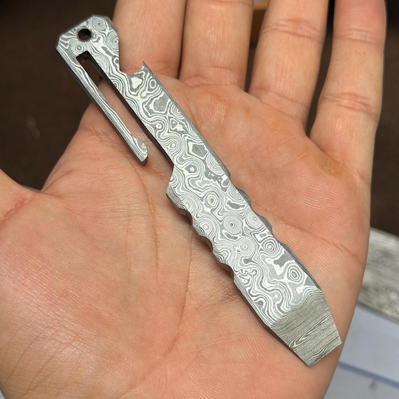 A hand-forged Damascus steel pry bar is the kind of EDC tool that makes other guys ask 'where did you get that?' — functional metalwork art you actually carry.
