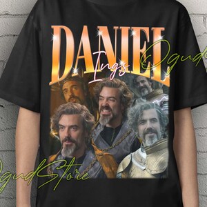 May include: Black unisex t-shirt featuring a collage of images and the name "DANIEL" in an orange and gold gradient font. The shirt also has the text "Unisex T-Shirt" in yellow.