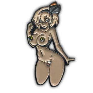 Puede incluir: Un pin que representa una figura femenina desnuda de estilo anime con piel bronceada, cabello rubio y un lazo negro. El pin tiene un contorno negro y est&aacute; en una pose de rodillas. La figura tiene acentos verdes y amarillos en el pecho.