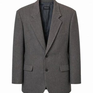 Könnte beinhalten: Ein anthrazitfarbener Blazer mit steigendem Revers, zwei schwarzen Knöpfen an der Vorderseite und zwei Pattentaschen. Das Innere ist mit dunklem Stoff gefüttert und enthält ein Etikett mit dem Text Signature am Halsausschnitt.