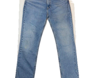 May include: A pair of light blue denim jeans featuring a classic five-pocket design, a button and zipper fly closure, copper-toned rivets, and a straight-leg cut with subtle fading along the thighs and knees for a worn-in appearance.