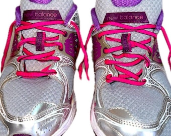 May include: A pair of New Balance Stability sneakers in gray, silver, and purple with bright pink laces. The shoes feature a mesh upper, silver synthetic overlays, and a purple tongue label with the text New Balance Stability.