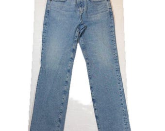 May include: Light blue denim jeans featuring a classic five-pocket design, a button and zipper fly closure, and a straight-leg cut. The hem of the jeans is finished with a raw, frayed edge, providing a textured look to the bottom of the legs.