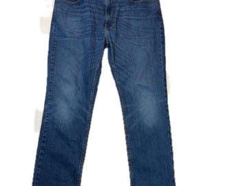 May include: A pair of blue denim jeans featuring a classic five-pocket design, a button fly closure, and a straight-leg cut. The fabric displays a medium wash with subtle fading along the thighs and knees, finished with contrast stitching.