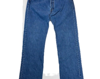 May include: A pair of medium-wash blue denim jeans featuring a classic five-pocket design, a button-fly closure, copper-toned rivets, and a straight-leg cut. The denim fabric displays a consistent blue tone with subtle fading along the seams.