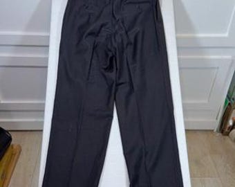 May include: A pair of dark charcoal gray trousers featuring a structured waistband, a center zipper fly, and two back pockets with button closures. The pants have a straight-leg cut with a clean, pressed crease running down the front of each leg.