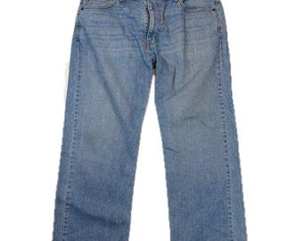 May include: Light blue denim jeans featuring a classic five-pocket design, a button fly closure, and a straight-leg cut. The fabric displays a faded wash with subtle whiskering details at the hips and a standard waistband with belt loops.