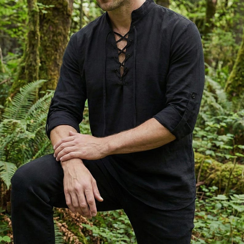 Pode incluir: Camisa preta de manga comprida com gola mandarim e frente com atacadores. As mangas est&atilde;o enroladas at&eacute; aos cotovelos. A camisa &eacute; feita de um tecido macio e respir&aacute;vel. A camisa faz parte de uma cole&ccedil;&atilde;o de roupas.