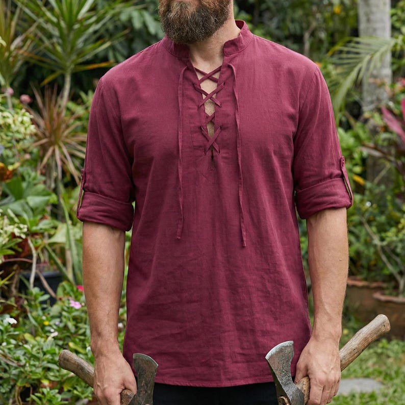 Pode incluir: Uma camisa bord&ocirc; com decote com cadar&ccedil;o e mangas enroladas. A camisa tem gola mandarim e &eacute; feita de um tecido leve. A camisa &eacute; de estilo casual, adequada para o uso di&aacute;rio.