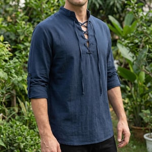 Pode incluir: Uma camisa azul marinho de manga comprida com gola mandarim e decote com atacadores. A camisa tem punhos abotoados e &eacute; feita de um tecido leve. A camisa &eacute; de estilo casual.
