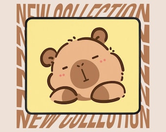 May include: A beige mousepad featuring a cartoon bear with closed eyes and rosy cheeks. The bear is centered on a yellow background, framed by a black border. The words "NEW COLLECTION" are printed in brown on the background.