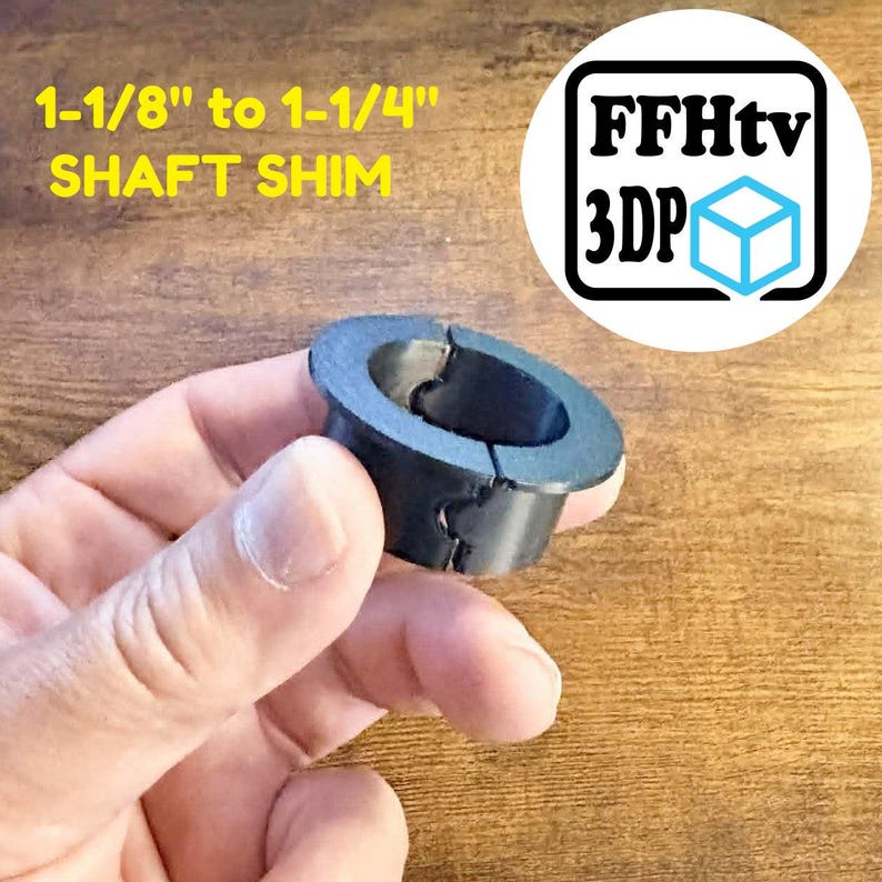 K&ouml;nnte beinhalten: Eine schwarze zylindrische Wellenpassfeder mit einem Flansch oben und einem vertikalen Schlitz an der Seite. Der Text 1-1/8" to 1-1/4" SHAFT SHIM ist in Gelb gedruckt, und ein Logo mit dem Text FFHtv 3DP und einem blauen W&uuml;rfelsymbol ist sichtbar.