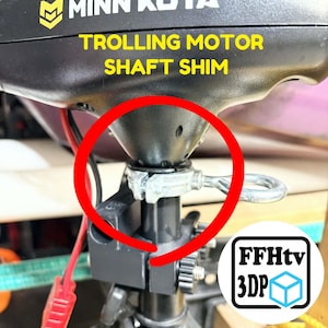 K&ouml;nnte beinhalten: Ein schwarzer Minn Kota Trolling-Motor-Wellenshim, installiert an einer Motorwelle, mit einer metallisch silbernen Klemme und einer Ringschraube. Das Bild enth&auml;lt gelben Text TROLLING MOTOR SHAFT SHIM und ein wei&szlig;es FFHtv 3DP Logo.