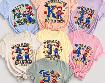 May include: A collection of seven short-sleeved t-shirts in light blue, peach, lavender, cream, yellow, pink, and gray. Each shirt features a graphic of Mario holding a diploma, school supplies, and text indicating grade levels from Pre-K to 5th grade.