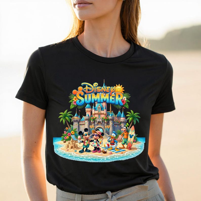 May include: A black t-shirt featuring a colorful graphic of Disney characters including Mickey, Minnie, Donald, and Goofy on a beach in front of a castle. The text "Disney SUMMER" is printed in blue and yellow above the castle illustration.