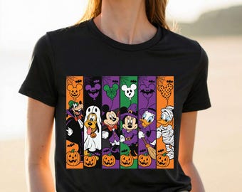 May include: A black short-sleeved t-shirt featuring a graphic print of Disney characters in Halloween costumes. The design includes Goofy, Pluto, Mickey, Minnie, Daisy, and Donald Duck arranged in vertical stripes with pumpkins and balloons.