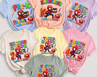 May include: A collection of seven short-sleeved t-shirts in various pastel colors, each featuring a graphic of Spider-Man holding a small chalkboard, a red apple, and text indicating school grade levels from Pre-K to Fifth Grade and the year 2026.