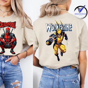 May include: Beige t-shirt featuring a Deadpool graphic on the front and a Wolverine graphic on the back. The Deadpool design shows the character in a crouching pose. The Wolverine design shows the character in a running pose.